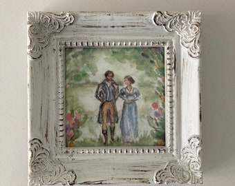 May include: A white, ornate picture frame with a distressed finish. The frame contains a watercolor painting of a couple standing in a garden setting.