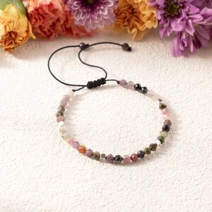 May include: A white ceramic mug with a black handle and the text "But First, Coffee" in a handwritten style. The mug is on a white surface. The mug is approximately 4 inches tall.