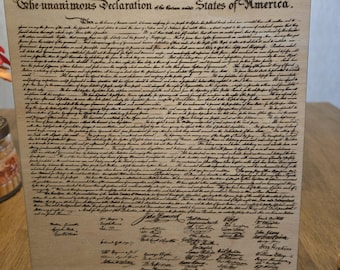 May include: A wood plaque with a black and white image of the Declaration of Independence. The text reads "IN CONGRESS. JULY 4. 1776. The unanimous Declaration of the thirteen united States of America."