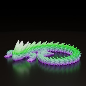 Peut inclure: Figurine de dragon imprimée en 3D, dans des tons de vert, de violet et de blanc. Le dragon est couché, son corps courbé et sa tête tournée vers l'avant. La figurine présente un design détaillé et texturé.