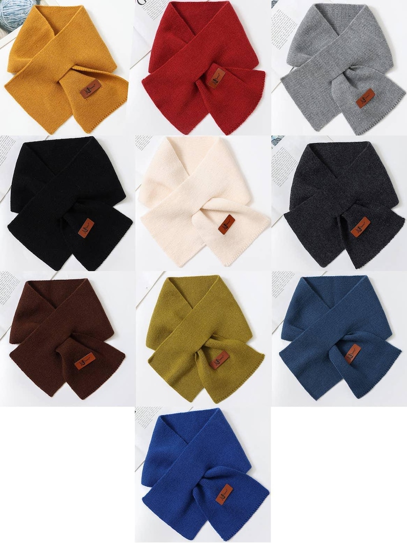 K&ouml;nnte beinhalten: Neun Schals in verschiedenen Farben, darunter Senfgelb, Rot, Grau, Schwarz, Creme, Anthrazit, Braun, Olivgr&uuml;n und Blau. Jeder Schal hat eine passende Tasche und ein kleines rechteckiges Lederetikett.