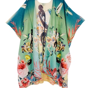 May include: A colorful kimono-style garment with a floral and hummingbird print. The open-front robe features a vibrant design with large flowers, hummingbirds, and musical notes. The color palette includes shades of blue, green, pink, and yellow.