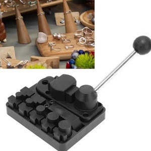 May include: A black metal ring mandrel with a lever handle. The mandrel has multiple sizes of ring mandrels and is used for sizing rings.