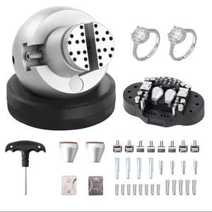 May include: A silver jewelry engraving ball vise on a black base, two silver rings with clear stones, a black accessory plate with metal pins, a T-handle hex key, and an assortment of various metal attachments, pins, and small silver components.