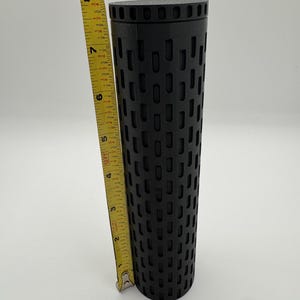 May include: A black cylindrical container with a patterned design. The container is approximately 8 inches tall.