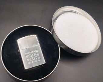 Encendedor vintage de mecha de seda cortada, década de 1990 a principios de la década de 2000, acabado cromado, con lata original.