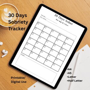 May include: A digital sobriety tracker on a tablet, featuring a 30-day calendar grid with space for notes. The text "30 Days Sober" and "One day at a time" are displayed. The image also includes a coffee cup and text indicating it's printable.