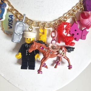 May include: A white ceramic mug with a black handle and the text "But First, Coffee" in a black, handwritten-style font. The mug is on a white surface.