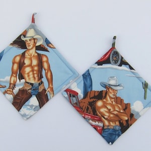 May include: Two blue and white cotton pot holders with a cowboy theme. One pot holder features a cowboy with a white hat and a red truck. The other pot holder features a cowboy with a white hat and a brown vest.