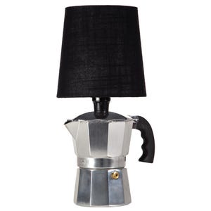 May include: A unique lamp featuring a silver stovetop espresso maker base with a black handle and a black lampshade. The lampshade is cylindrical and made of a textured fabric. The lamp has a modern, industrial design.