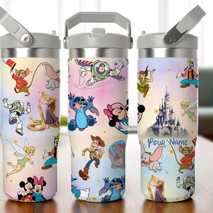 May include: Three stainless steel tumblers with Disney character designs. Each tumbler features a different design, including characters like Mickey and Minnie Mouse, Buzz Lightyear, and Stitch. The tumblers have a grey handle and lid.