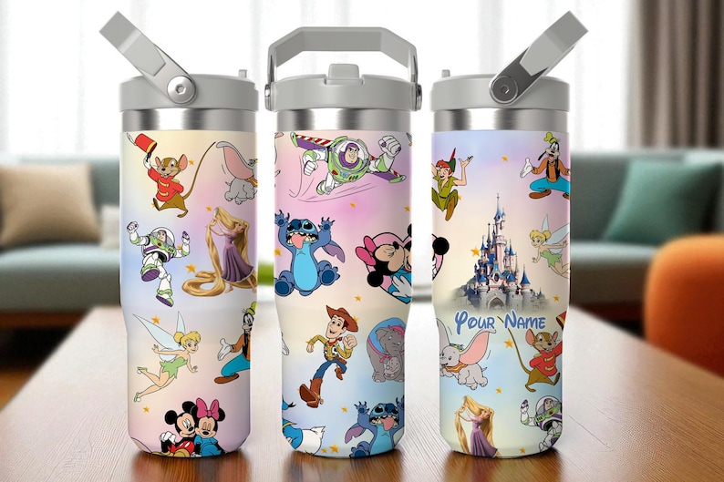 May include: Three stainless steel tumblers with Disney character designs. Each tumbler features a different design, including characters like Mickey and Minnie Mouse, Buzz Lightyear, and Stitch. The tumblers have a grey handle and lid.