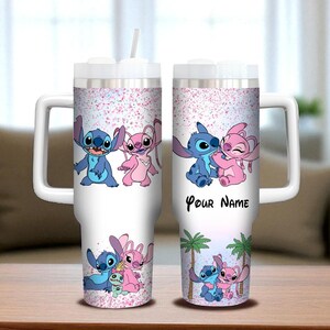 May include: White insulated tumbler featuring blue and pink cartoon characters, with a pink glitter design. The tumbler has a white handle and lid, and the text "Your Name" is printed on the side. A straw is included.