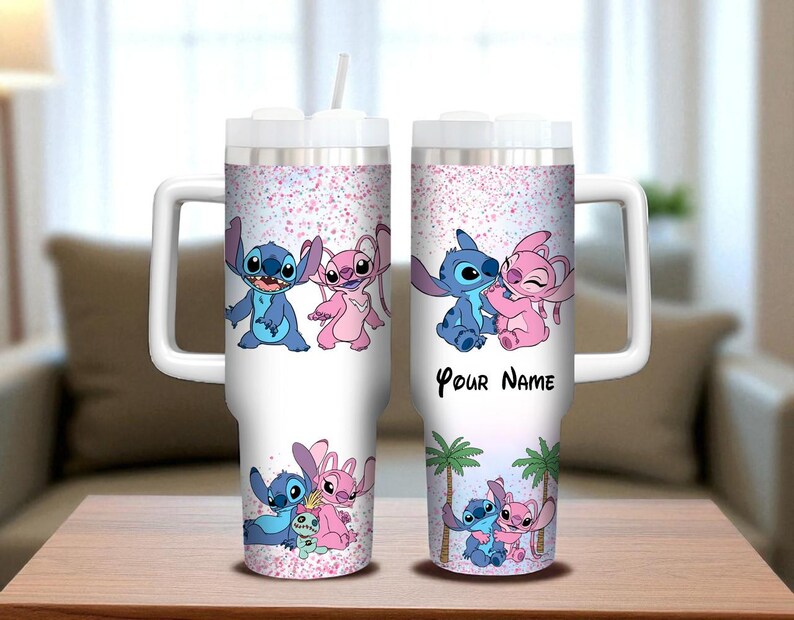May include: White insulated tumbler featuring blue and pink cartoon characters, with a pink glitter design. The tumbler has a white handle and lid, and the text "Your Name" is printed on the side. A straw is included.