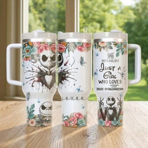 以下が含まれることがあります： 黒い持ち手と「But First, Coffee」の太字の黒い文字が入った白いセラミックマグ。マグカップはぼやけた背景に置かれています。マグカップの高さは約10cmです。