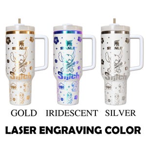 May include: Three white Stanley tumblers with laser-engraved Stitch designs. The tumblers have gold, iridescent, and silver accents, with matching lids and handles. The text at the bottom reads "GOLD", "IRIDESCENT", and "SILVER".