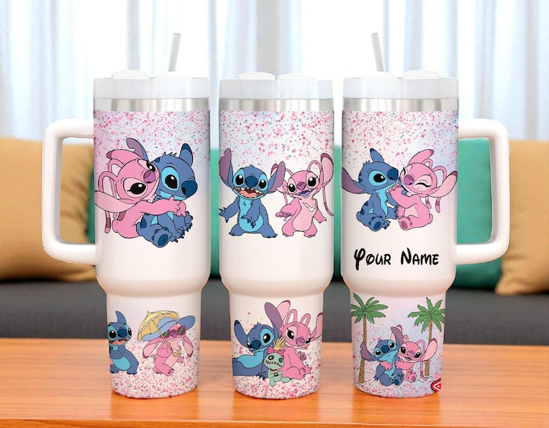 May include: White insulated tumbler with a handle, featuring a cartoon design of a blue and pink alien couple. The design includes the text "Your Name" on one tumbler. Each tumbler has a white lid and a straw.
