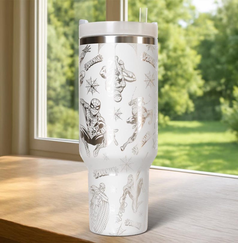 Pu&ograve; includere: Bicchiere termico bianco con un design di Spider-Man. Il bicchiere ha un coperchio bianco e una fascia argentata. Il design include illustrazioni di Spider-Man, ragnatele e la parola "Spider-Man" in un motivo ripetuto.
