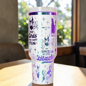 Puede incluir: Vaso de viaje blanco con tapa blanca y banda iridiscente p&uacute;rpura. El vaso est&aacute; decorado con ilustraciones de villanos de Disney y el texto "BAD Girls HAVE MORE FUN" y "ON WEDNESDAY WE WEAR Black".