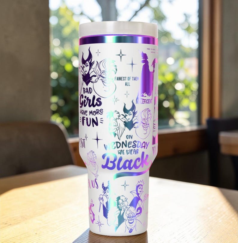 Puede incluir: Vaso de viaje blanco con tapa blanca y banda iridiscente p&uacute;rpura. El vaso est&aacute; decorado con ilustraciones de villanos de Disney y el texto "BAD Girls HAVE MORE FUN" y "ON WEDNESDAY WE WEAR Black".