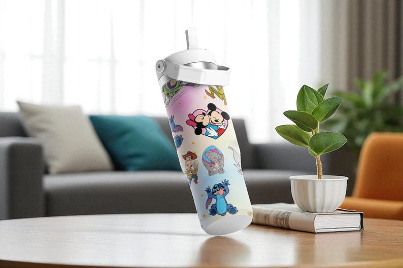 May include: A water bottle with a white lid and straw, decorated with Disney characters including Mickey and Minnie Mouse, and Stitch. The bottle is set against a background with a sofa, cushions, and a small plant.