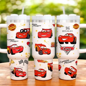May include: Three white insulated tumblers with Lightning McQueen graphics. Each tumbler features a white handle, a white lid, and a straw. The tumblers are decorated with images of the red race car, stars, and the words "Lightning McQueen" and "Cars".