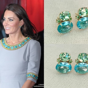 Peut inclure: Une paire de boucles d'oreilles avec un design de pierres précieuses bleu clair et vert. Les boucles d'oreilles sont de forme ovale et ont un sertissage en or.