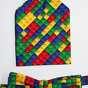 Puede incluir: Un conjunto de pajarita y pañuelo de bolsillo con un colorido patrón tipo Lego en rojo, amarillo, azul y verde.