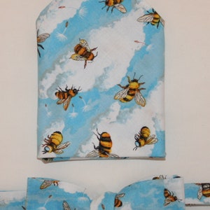 May include: A blue and white bow tie and pocket square with a bee and cloud pattern.