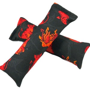 May include: Two black cat toys with a red and orange devil cat pattern. The cat toys are rectangular and filled with catnip. The devil cat design includes flames, pitchforks, and devil cats.