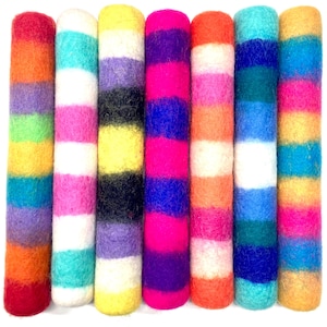 May include: A collection of seven colorful, cylindrical felted wool items. Each is a different color combination, with horizontal stripes of various hues including red, orange, yellow, pink, blue, and purple. The felted wool has a slightly textured appearance.