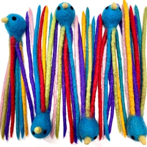 May include: A collection of handmade felt bird ornaments. Each bird has a blue body, yellow beak, and black eyes. The colorful tails are made of various colors, including red, purple, yellow, and pink. These whimsical ornaments are perfect for adding a touch of color.