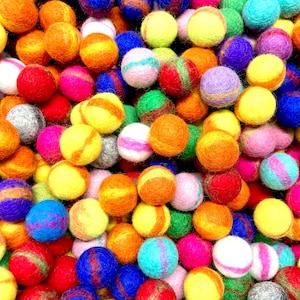 May include: A vibrant assortment of colorful felt balls in various shades of orange, yellow, pink, green, blue, and purple. Some balls have striped patterns. These decorative balls are ideal for craft projects.