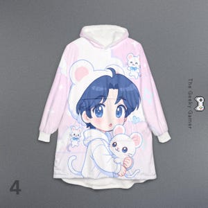 May include: A pink and white hooded blanket featuring an anime-style illustration of a character with blue hair and large blue eyes, wearing a mouse-eared hat and holding a white mouse. The blanket has a white fleece lining and the text "The Geeky Gamer".