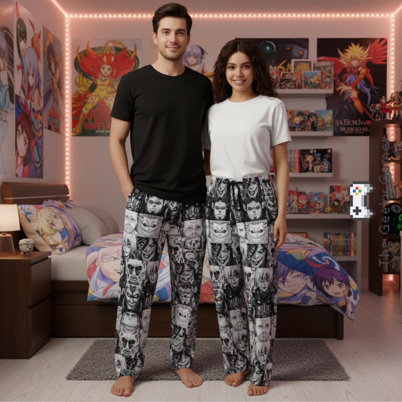 Op de afbeelding: Een stel staat naast elkaar, beiden gekleed in een pyjamabroek met een zwart-wit gezichtenpatroon. De persoon links draagt een zwart t-shirt, de persoon rechts een wit t-shirt. Anime posters zijn zichtbaar op de achtergrond.