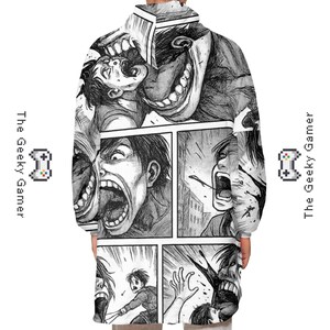May include: A black and white hooded sweatshirt featuring a manga-style comic strip design. The artwork depicts intense facial expressions and action scenes. The Geeky Gamer logo is on the sides.