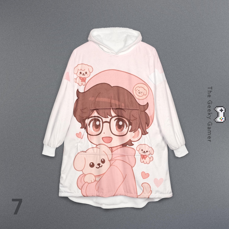 May include: White and pink hooded blanket featuring a cartoon illustration of a person with glasses and a dog. The design includes hearts and small dog illustrations. The Geeky Gamer logo is visible on the right side.