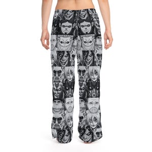 Op de afbeelding: Zwart-witte pyjamabroek met een herhaald patroon van gestileerde monstergezichten. De broek is gemaakt van een zacht materiaal en heeft een relaxte pasvorm. Het ontwerp is een unieke en opvallende graphic.