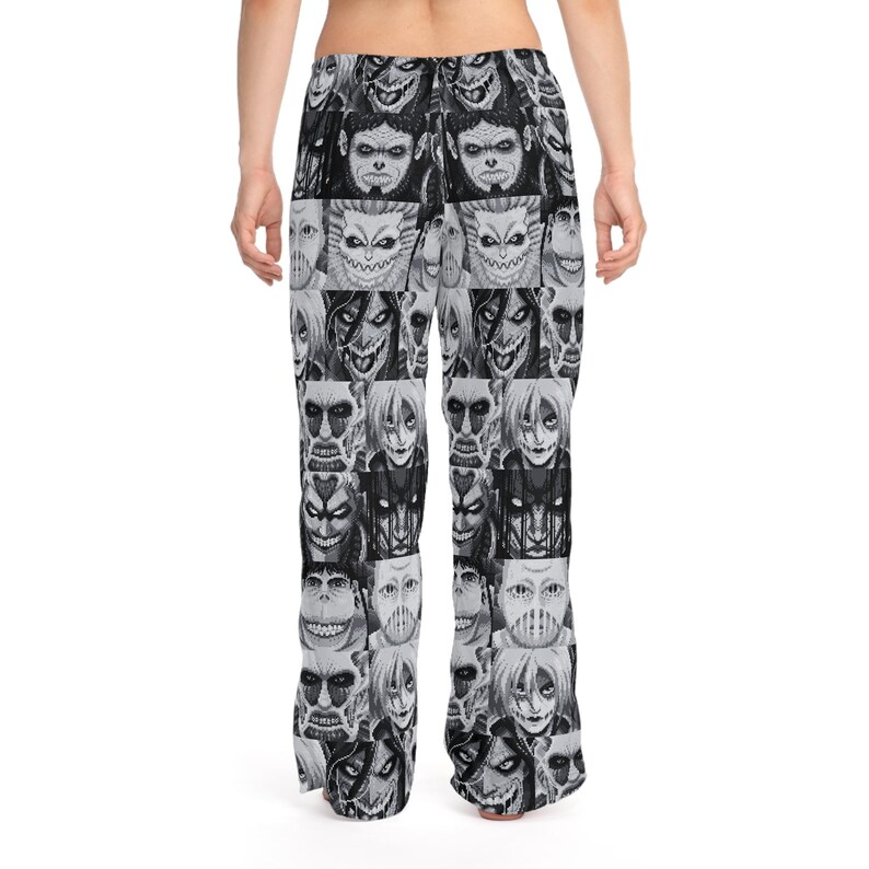 Op de afbeelding: Zwart-witte pyjamabroek met een herhaald patroon van gestileerde monstergezichten. De broek is gemaakt van een zacht materiaal en heeft een relaxte pasvorm. Het ontwerp is een unieke en opvallende graphic.