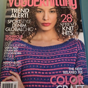 Puede incluir: Portada de la revista Vogue Knitting con una mujer que lleva un suéter de punto a rayas azul y rosa. El texto de la portada dice "Trend Alert! Sportstyle Denim Globalchic" y "28 Spring Knit Hits".