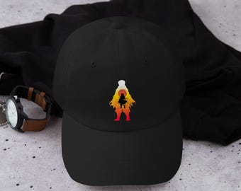 May include: Black baseball cap with a colorful graphic of a figure against a sunset backdrop. The graphic features shades of red, orange, and yellow. The cap is made of a soft material and has a curved brim.