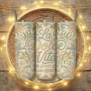 Puede incluir: Tres vasos aislados con pajitas negras, con un diseño floral beige y el texto "La Dolce Vita - The Sweet Life - Italian Lifestyle". Los vasos están colocados sobre una cesta tejida.