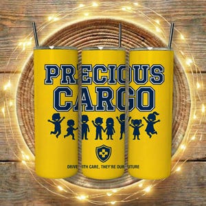 Puede incluir: Tres vasos aislados amarillos con pajitas negras. Cada vaso presenta el texto "PRECIOUS CARGO" en azul y blanco, con un gráfico de niños. La parte inferior de los vasos dice "DRIVE WITH CARE, THEY'RE OUR FUTURE".