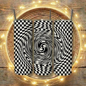 May include: Three stainless steel tumblers with black and white checkered and swirling optical illusion designs. Each tumbler has a silver straw and sits on a woven basket, with string lights around the basket. The background is a wooden surface.