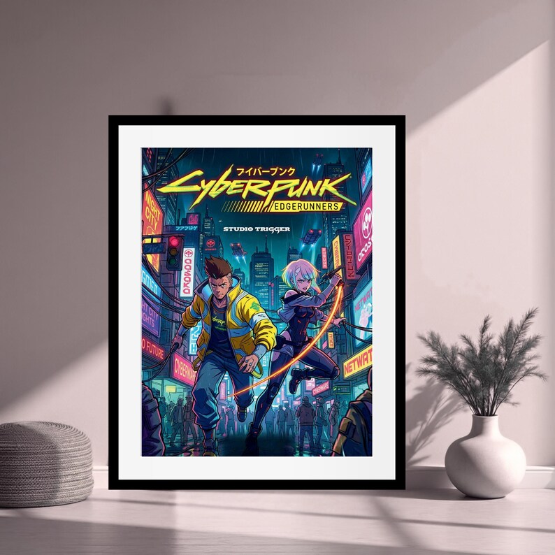 May include: Framed artwork depicting a futuristic cityscape with neon signs and two characters in action. The artwork displays the title "Cyberpunk Edgerunners" in bold, stylized lettering, with Japanese text above. The characters are in dynamic poses, set against a backdrop of a bustling city.