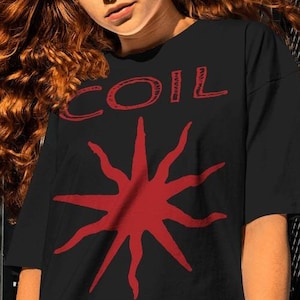 May include: A black t-shirt featuring a red starburst design and the word "COIL" in red lettering.
