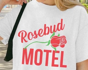May include: White oversized t-shirt with a red graphic of a rose and the text "Rosebud Motel".