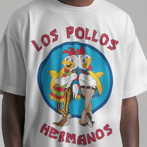 Peut inclure: T-shirt blanc avec un imprimé graphique de deux poulets de dessin animé portant des sombreros et le texte "Los Pollos Hermanos".