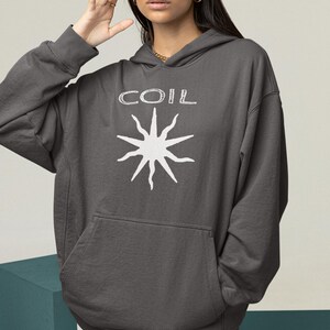 May include: A charcoal gray hooded sweatshirt with a white graphic of a sun with the word "COIL" above it.