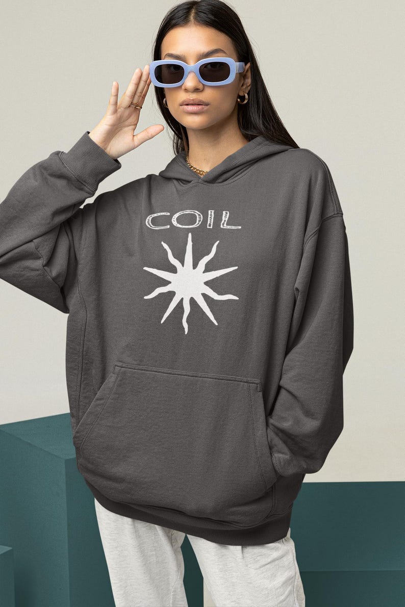May include: A charcoal gray hooded sweatshirt with a white graphic of a sun with the word "COIL" above it.